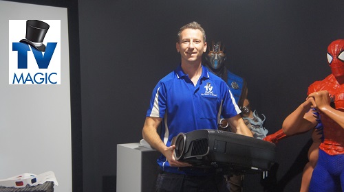 a technician holding a projector ready for installation in a partially completed home theatre