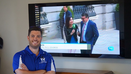 technician in front of a TV mounted on a wall