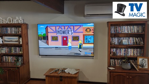 a wall mounted TV in a living room. TV Magic logo in top right corner