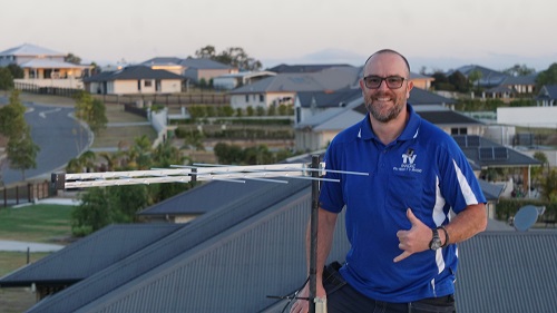 Technician on a roof with an aerial he just installed.