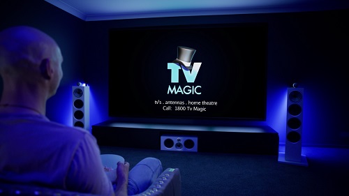 Image of a TV Magic home cinema with client sitting in front.