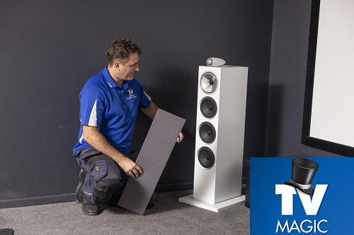Technician with home theatre equipment he is installing.
