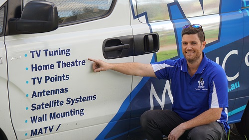 Technician pointing to home theatre service on side of van