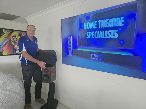 Technician with various home theatre gear.