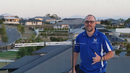 Technician on a roof with an antenna installation he just completed