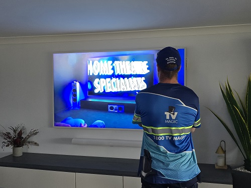 Technician facing a TV he installed in Ellen Grove.