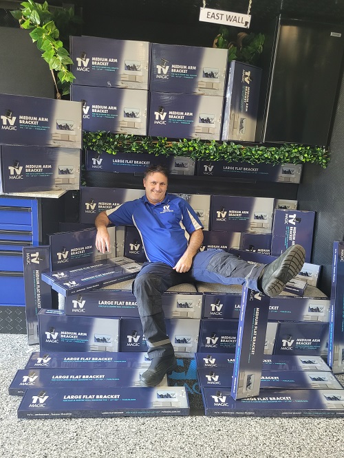 Technician surrounded by TV Magic TV wall mounting brackets.