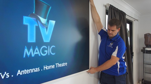 Technician mounting a large TV