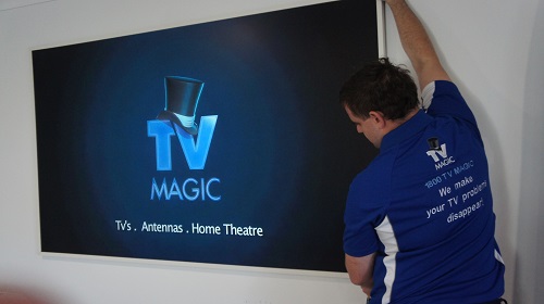 Technician wall mounting a TV