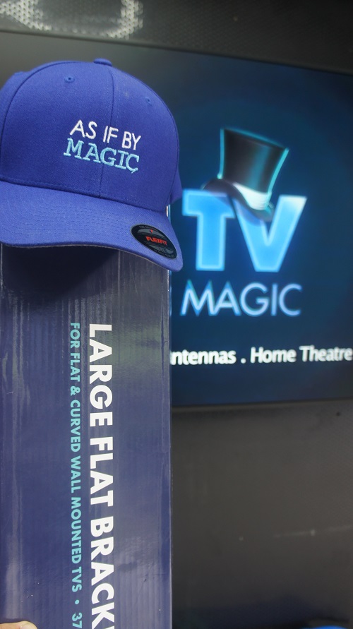A TV Magic wall bracket in front of a large TV screen