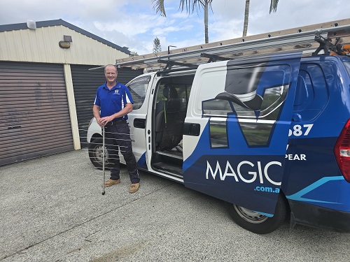Technician standing next to his van holding an antenna