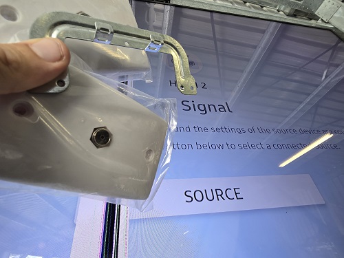 Close up of a technician holding a TV point up to a TV