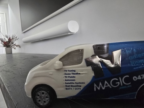 close up of a soundbar installation with a mini TV Magic van in front of it.