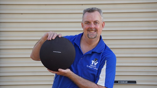 Technician - Anton, holding a speaker ready for installation.