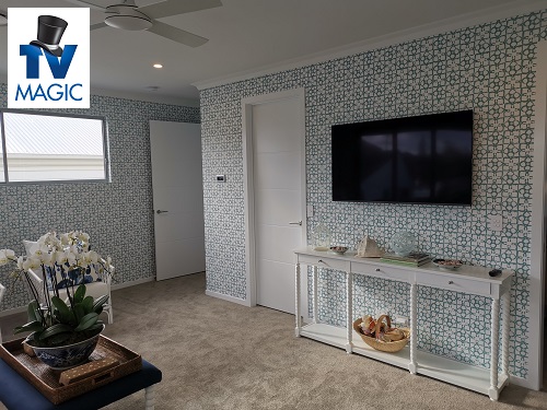 a wall mounted TV in a living room. TV Magic logo in top left corner