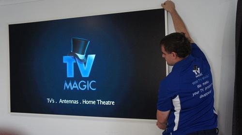 Technician installing a large TV