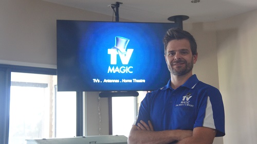 a picture of your technician Alex, in front of a wall mounted TV with TV Magic logo on screen