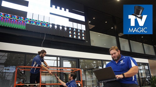 Technician in a commercial setting attending to a TV damage report