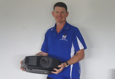 Technician - Brendan, holding a projector ready for installation
