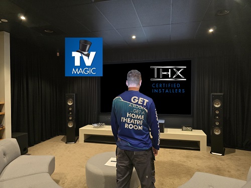 Technician with back facing outwards in front of a TV Magic home cinema