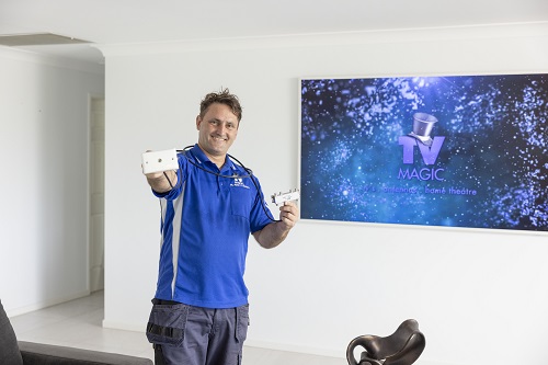 Technician in a customer living room, holding a TV point