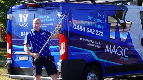 technician - Carl, standing at the side of his van, holding an antenna