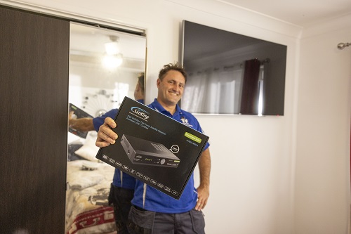 Technician holding a vast TV box