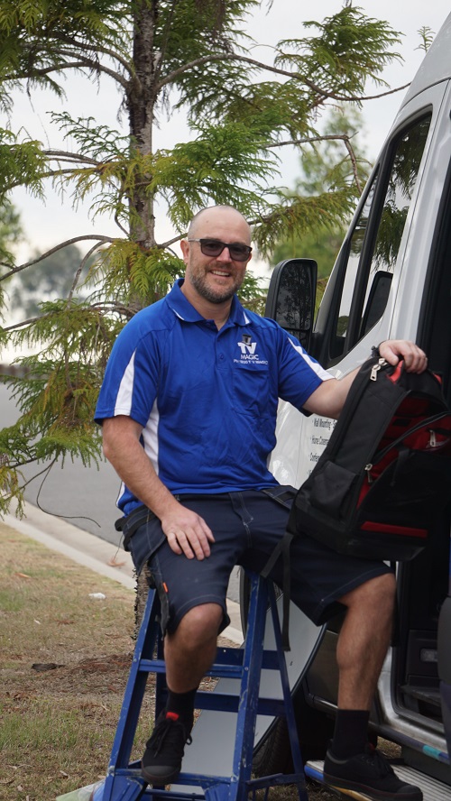 Technician - Vaughan, sitting on a small ladder, next to his van