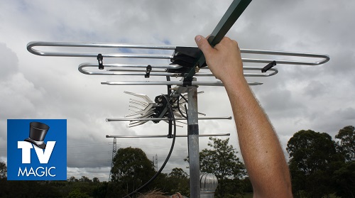 a technician with an antenna in hand - close up. TV Magic logo in corner