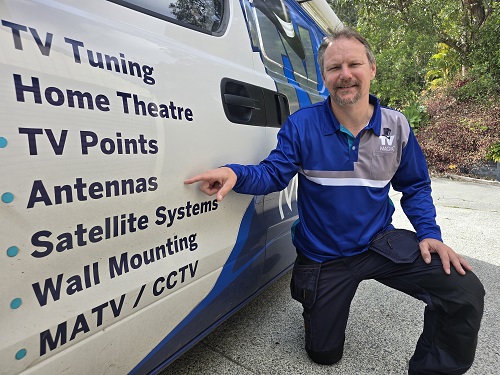 Technician pointing to the antenna service on the side of van