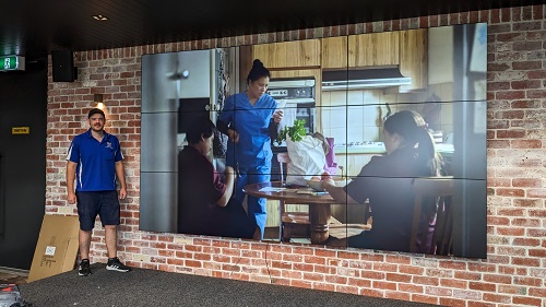 technician in front of a multi-TV display