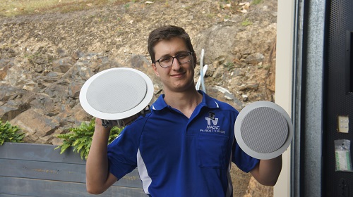 A technician with speakers in hand.