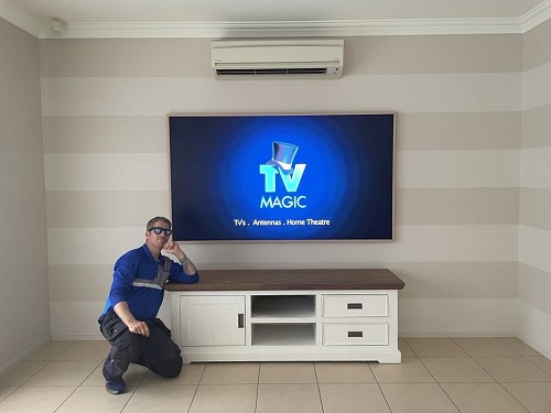 a technician with a new Samsung Frame TV Installation with a TV Magic logo up on the screen