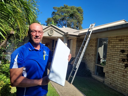 Technician holding up a Starlink dish