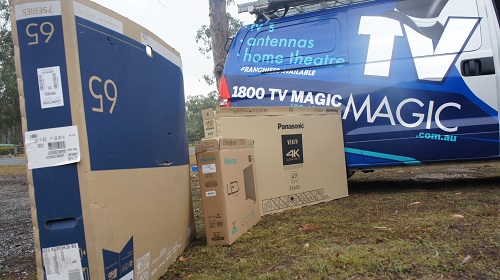 TV Magic van with multiple TV boxes in front of it.