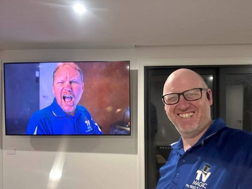 Technician in front of a TV he wall mounted
