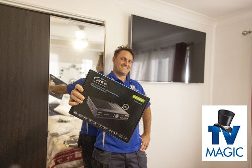 Technician holding up a vast box, standing in client bedroom.
