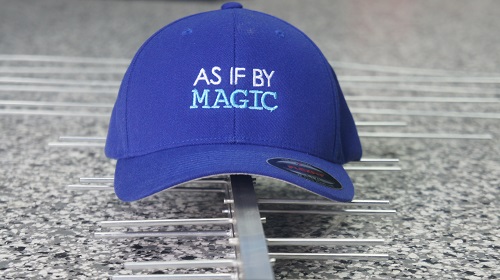 An antenna laying flat with a TV Magic cap on top that says "As If By Magic"