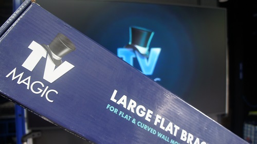 Close up of a TV Magic wall bracket in front of a TV with logo on it