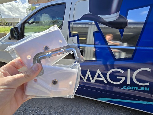 Technician holding up TV point components in front of his van