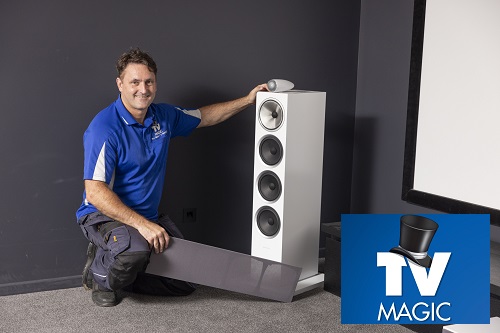 Technician with speakers and other devices in a home cinema he was building in Kingscliff.