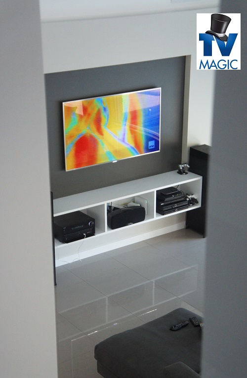 a wall mounted TV with other AV equipment installed. TV Magic logo included