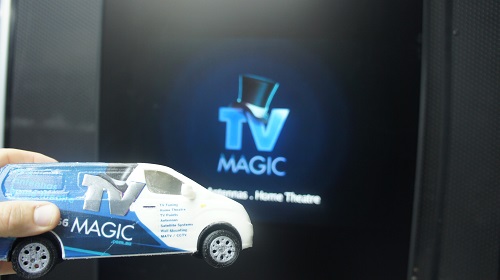 TV with TV Magic logo on screen. Mini TV Magic van held by technician in front