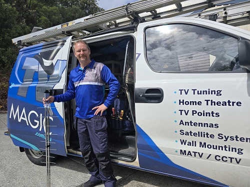 Technician standing with an antenna, next to his van