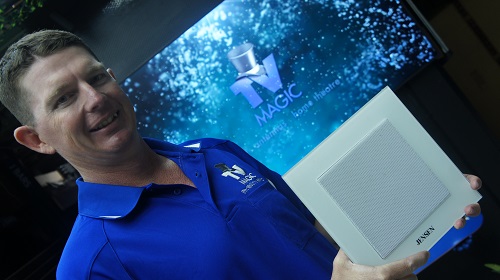 Technician in front of a large screen, holding speakers