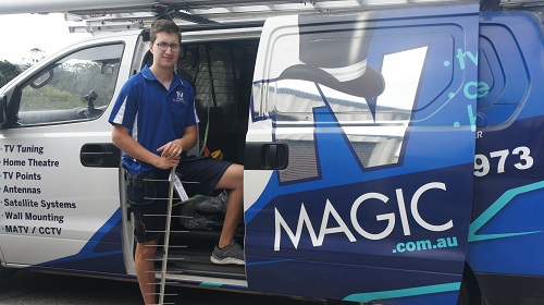 Technician holding an antenna, standing next to TV Magic van
