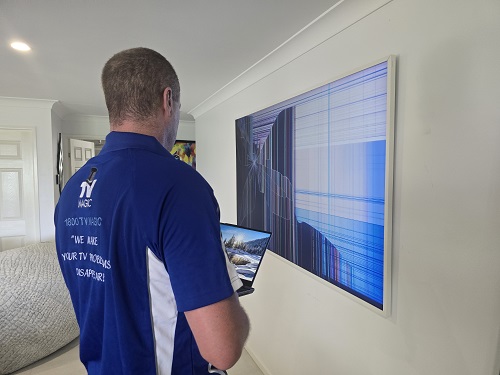 TV Magic technician assessing a broken TV screen.