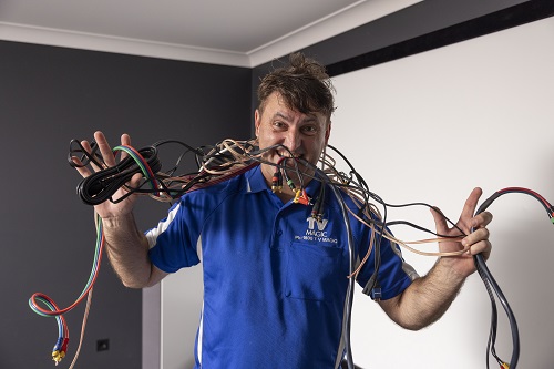 Technician with loads of cables in his mouth.