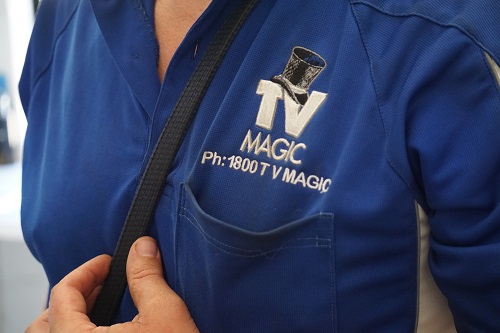 close up of technician - Sam, in TV Magic shirt