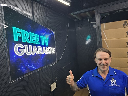Technician Chris next to the Free TV guarantee signage